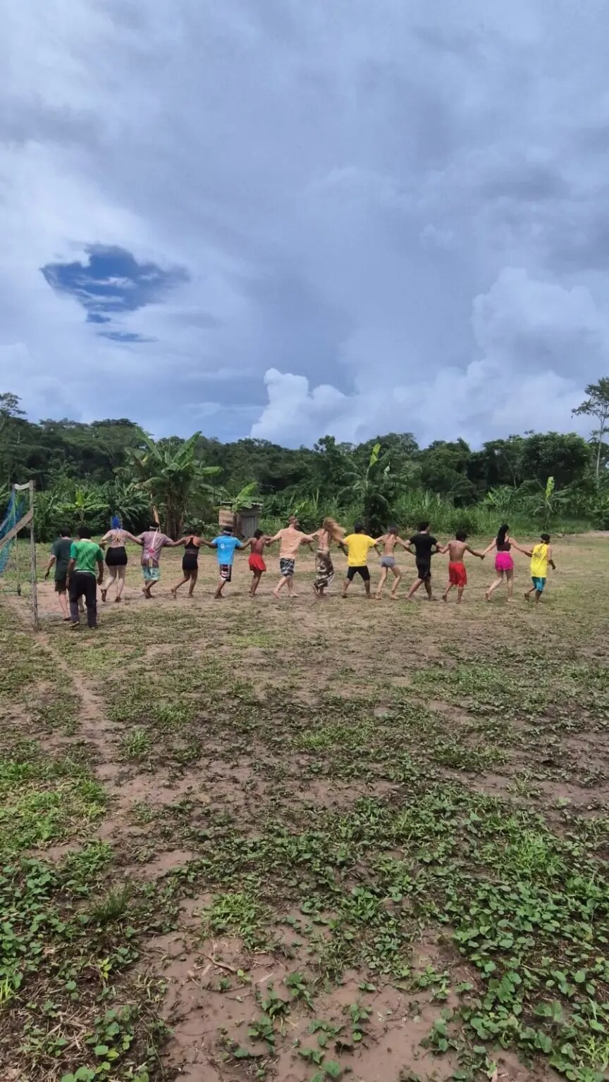 Participantes e jovens Huni Kuin em dança coletiva durante vivência na Aldeia Chico Curumim