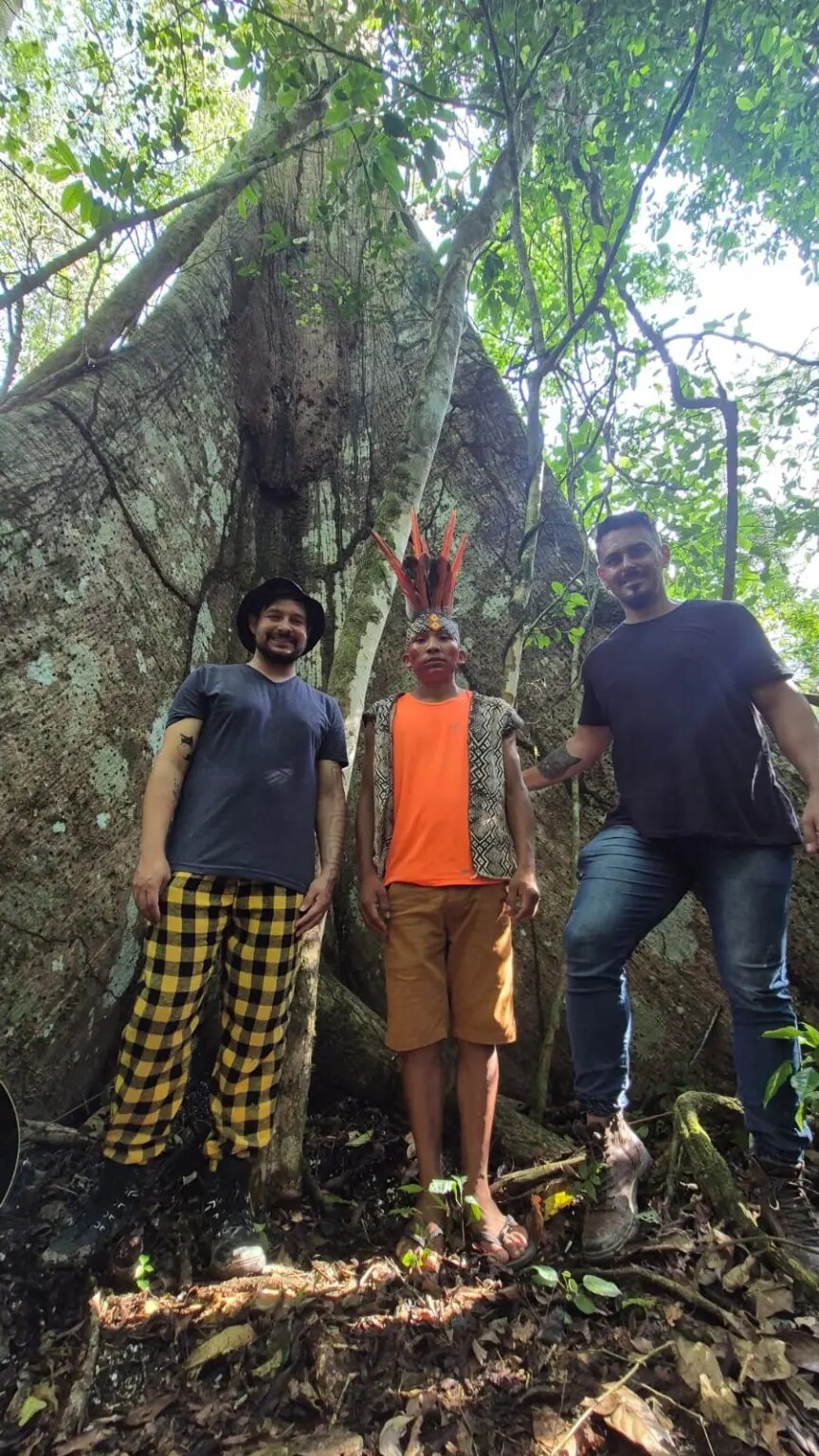 Bruno Luz e Michael Pereira ao lado de integrante Huni Kuin durante vivência na floresta acreana